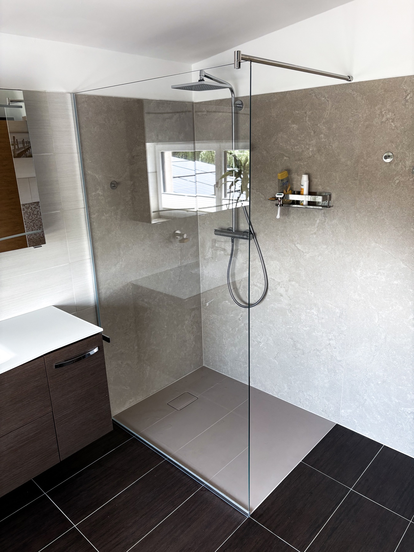 Offene Dusche mit klarer Glaswand und oberem Haltearm